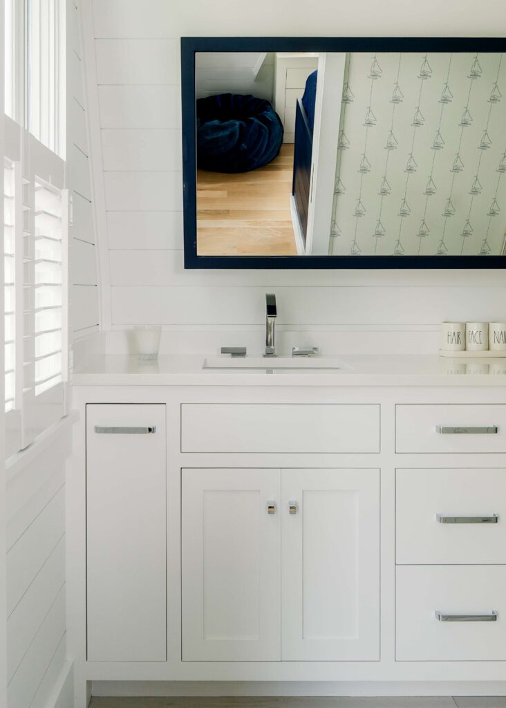 Seaview Avenue guest bathroom with chrome fixtures and delicate sailboat wallpaper 